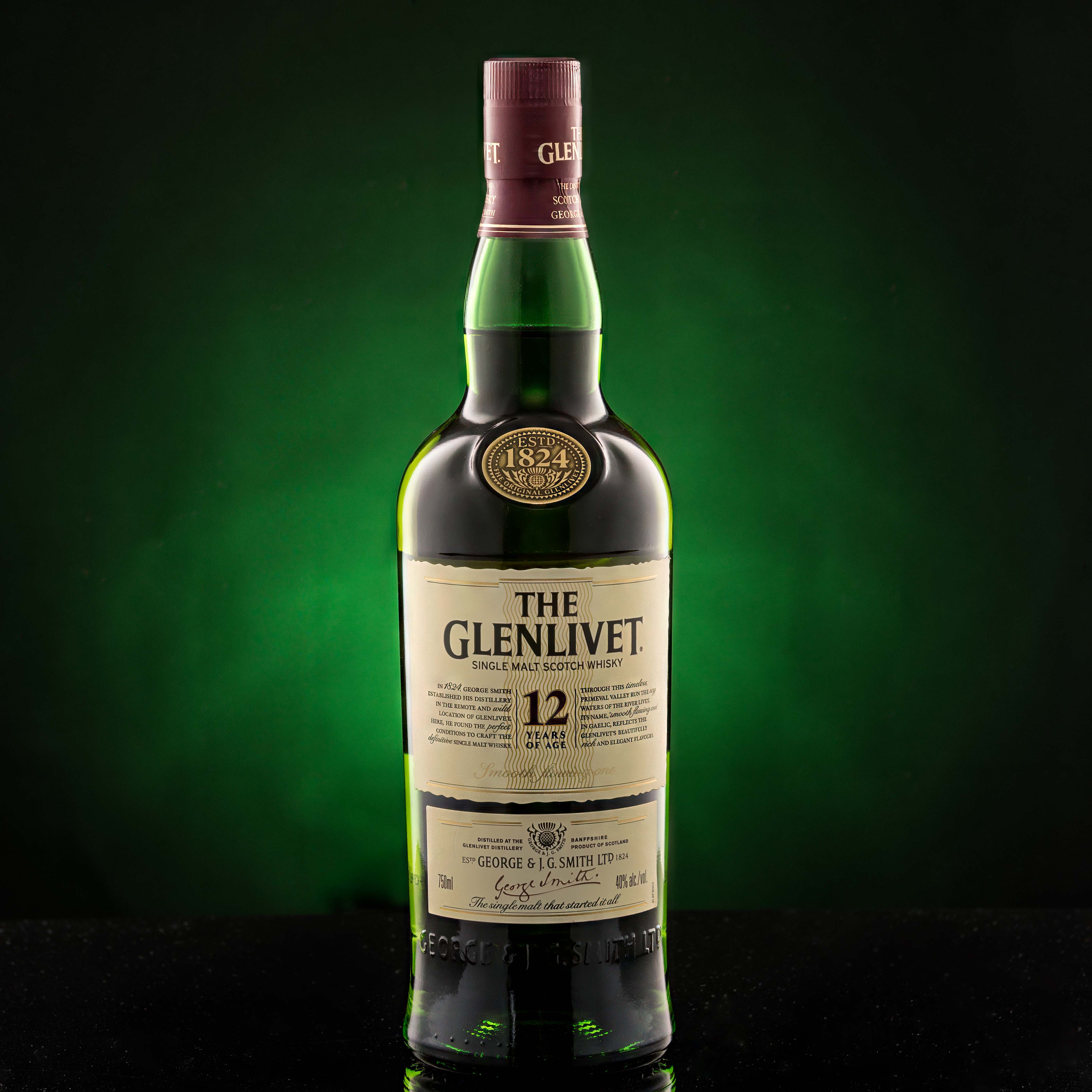 Bottle of scotch on non-white background - shot in studio Glenlivet 12 years on dark green gradient background shot in studio