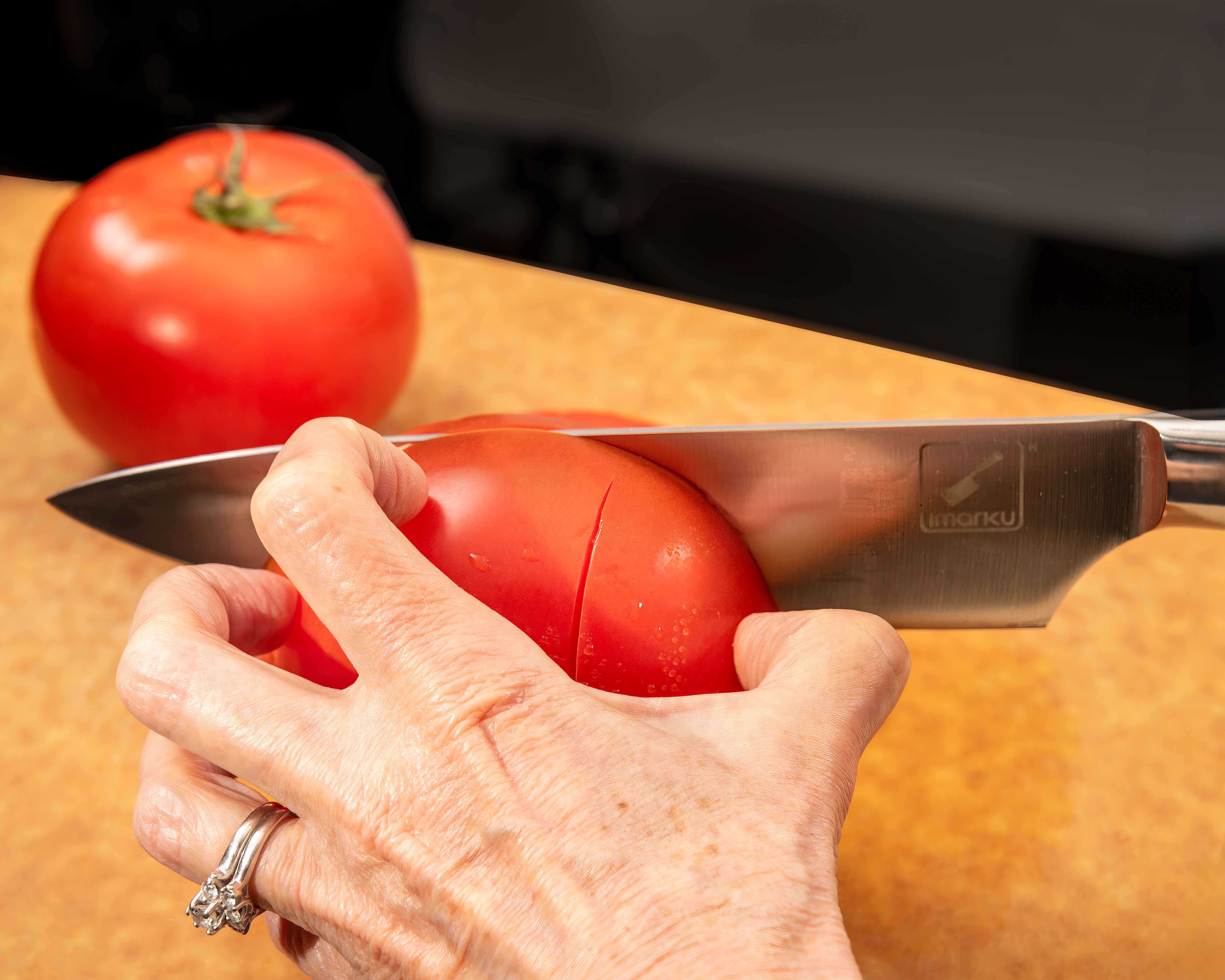 Chef knife slicing tomato composite - shot in studio chef knife slicing tomato composite shot in studio