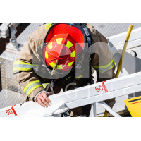 Firefighter backing down aerial ladder